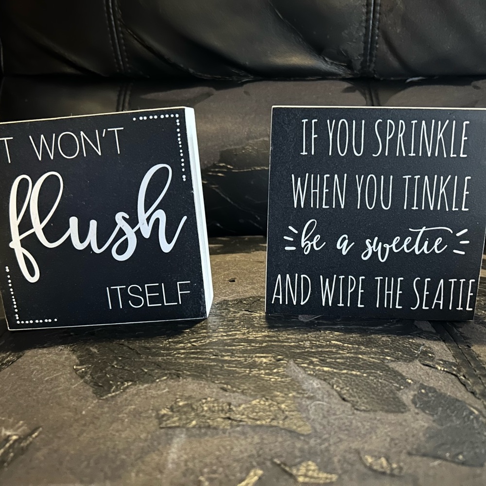 Two small wooden bathroom plaques.